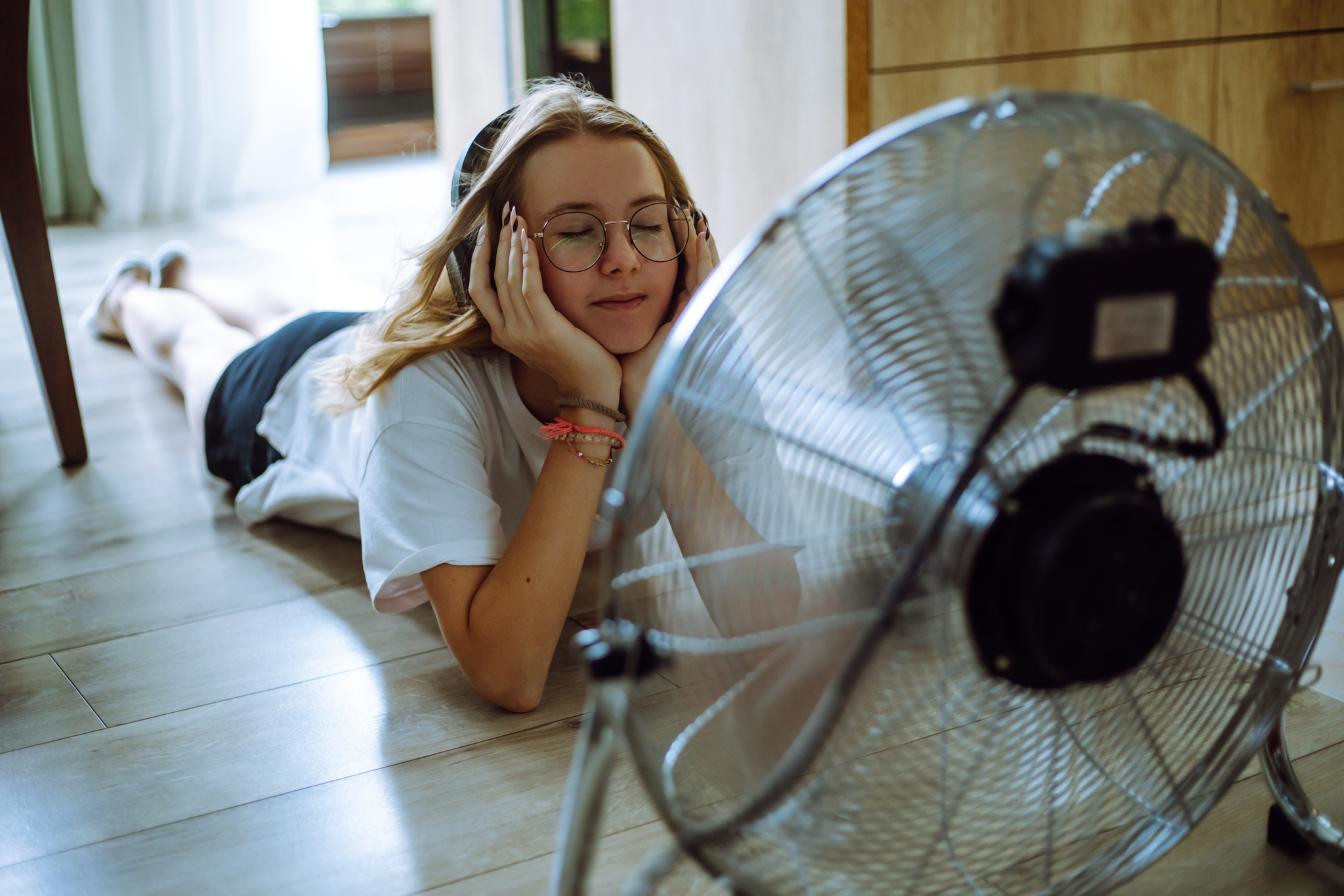 A girl is trying to calm down with a fan.