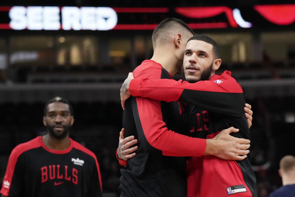 Lonzo Ball hugs teammate Nikola Vucevic before the match against Wolves.