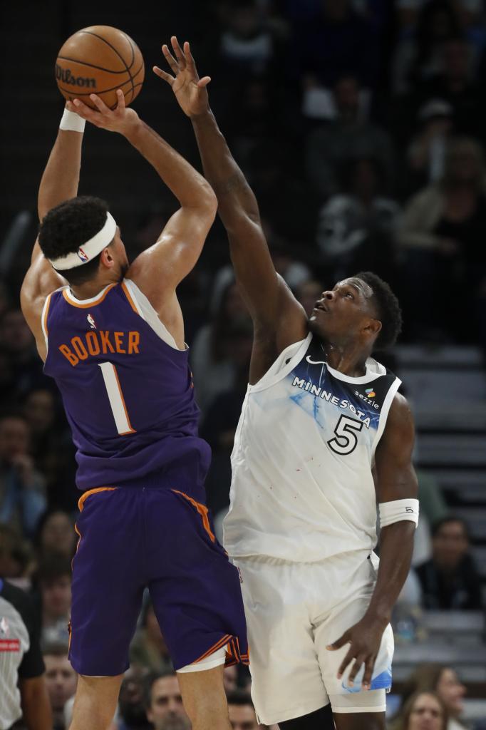 Devin Booker plays in the defense of Anthony Edwards.