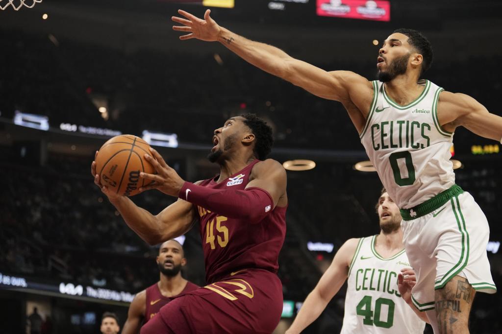 Cleveland Cavaliers guard Donovan Mitchell (45) goes to the basket in front of Boston Celtics forward Jason Tatum (0) in the first half of the NBA basketball game, Sunday, Dec. 1, 2024, in Cleveland. (Associated Press / Sue Ogrocki photo)