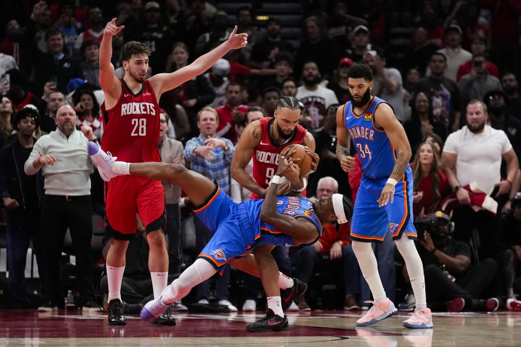 Houston Rockets forward Dillon Brooks (9) and Oklahoma City Thunder guard Shay gilgius Alexander try to control the ball during the second half of an NBA basketball game in Houston, Sunday, Dec. 1, 2024. (AFP photo / Ashley Landis)