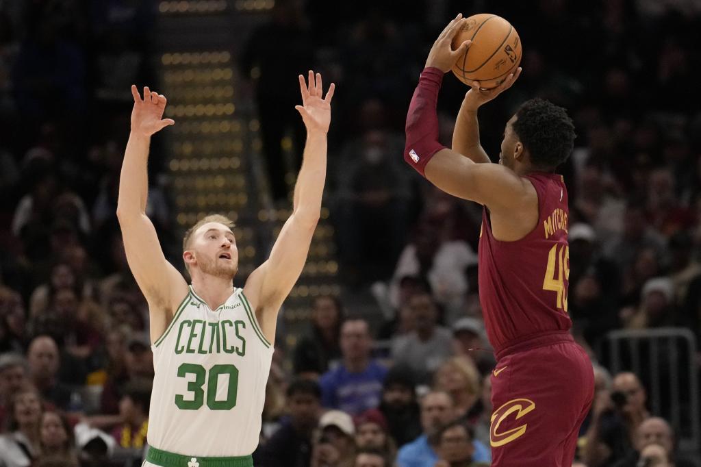 Cleveland Cavaliers guard Donovan Mitchell (45) prepares to shoot a 3-point basket over Boston Celtics forward Sam Hauser (30) in the second half of an NBA basketball game, Sunday, Dec. 1, 2024, in Cleveland. (Associated Press / Sue Ogrocki photo)