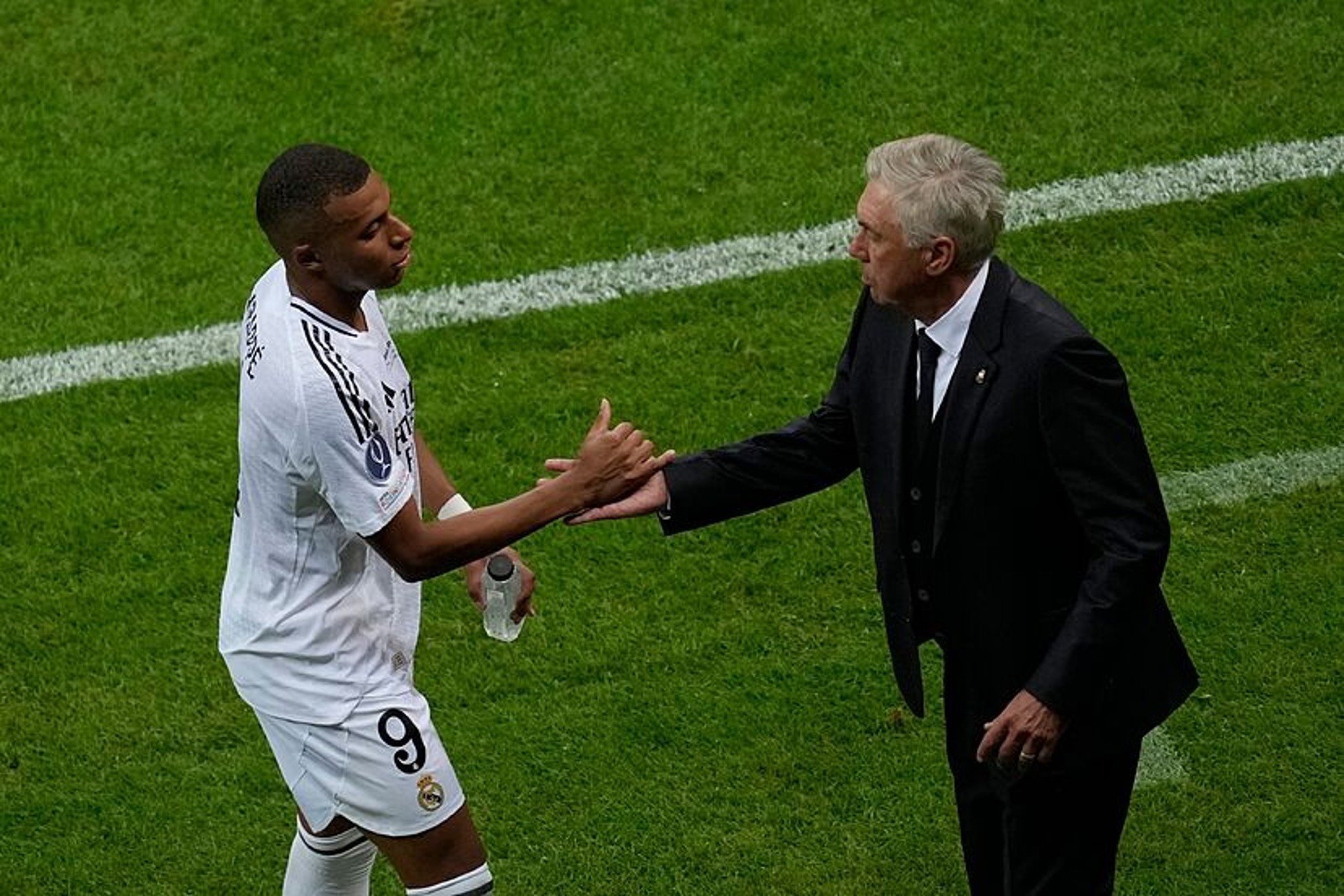 Mbappe and Ancelotti greet each other at the UEFA Super Cup.